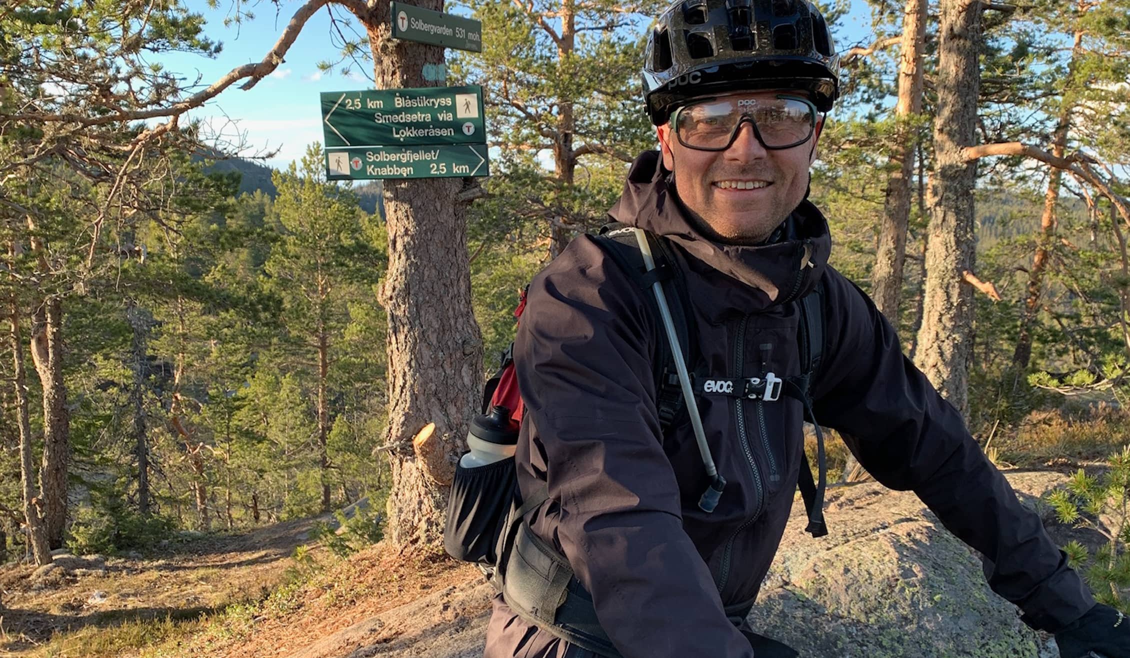 Foto. Mann med sykkelhjelm og briller i skogen.